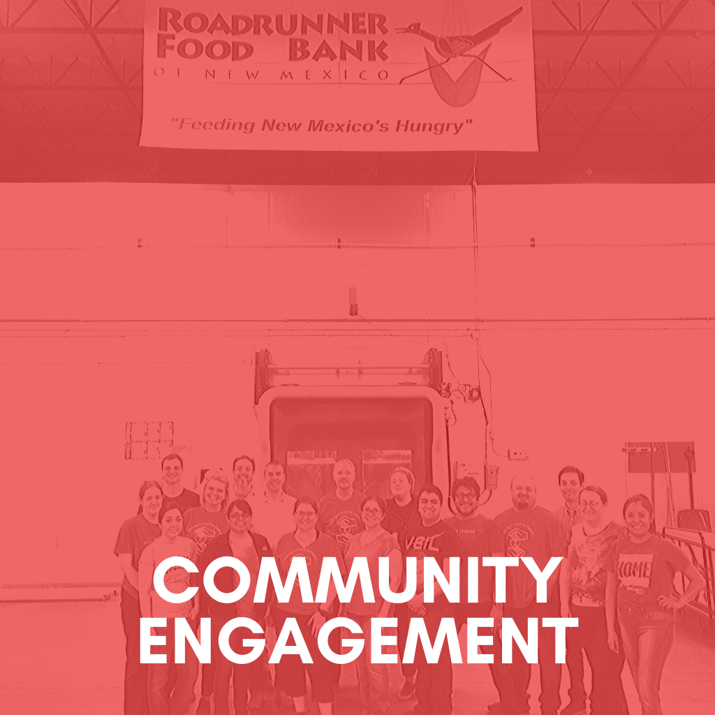 employees posing in front of the Roadrunner Food Bank banner.