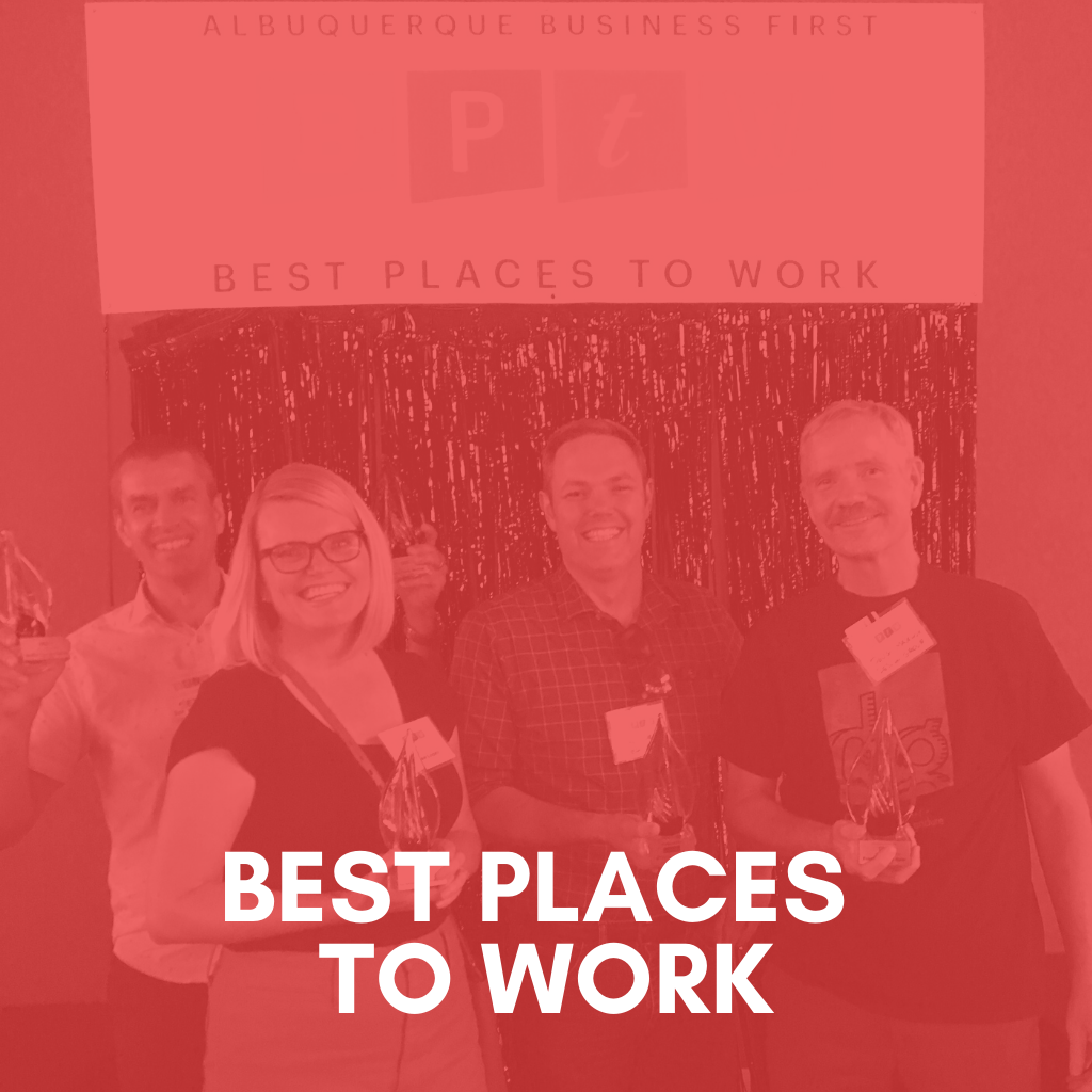 Four employees standing in front of a sign that says "voted best place to work".