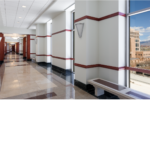 White hallway with redwood trim and white walls and a checkered marble floor.