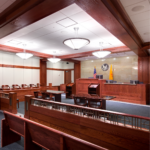 Wide shot of the courtroom with two podiums facing the judge and jury seats in the background.