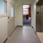 hallway view of the detainee area with the doorway showing a podium. 