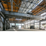 Interior view of the old Albuquerque Train Yard hanger with ceiling crane positioned in the middle of the building.