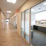 Well lit up hallway with offices on each side. 