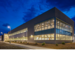 The exterior angle of the Chevron Field Office corner with interior lights on. 