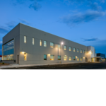 Outside view of the Chevron Field Office with exterior and interior lights on.