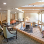 Two gray chairs overlooking the front lobby from the 2nd floor balcony.