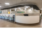 Front lobby check-in with green chairs in each cubicle.  