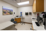 Exam room with a white counter and a gray exam cushion table. 