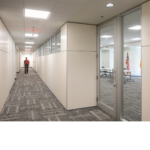 Hallway with white walls and gray pattern floor in the State of NM TIWA Building
