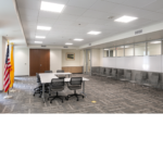 large room with white tables and grey chairs.