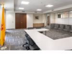 Conference room with white tables and grey chairs.